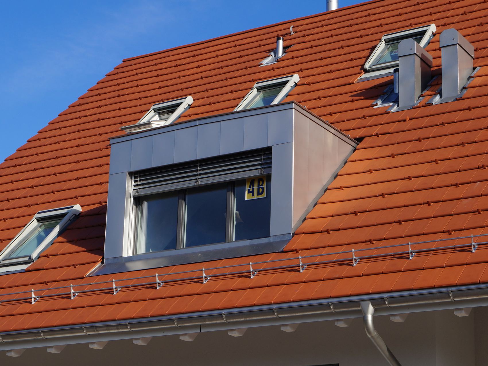 Lukarne mit Metallverkleidung auf einem Ziegeldach